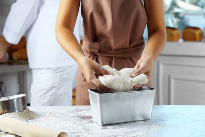 Fazendo massa por mãos femininas na padaria