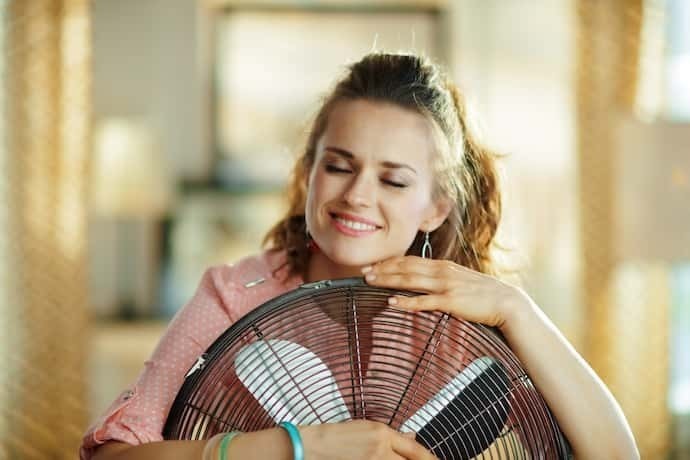 Uma mulher abraçando o ventilador 