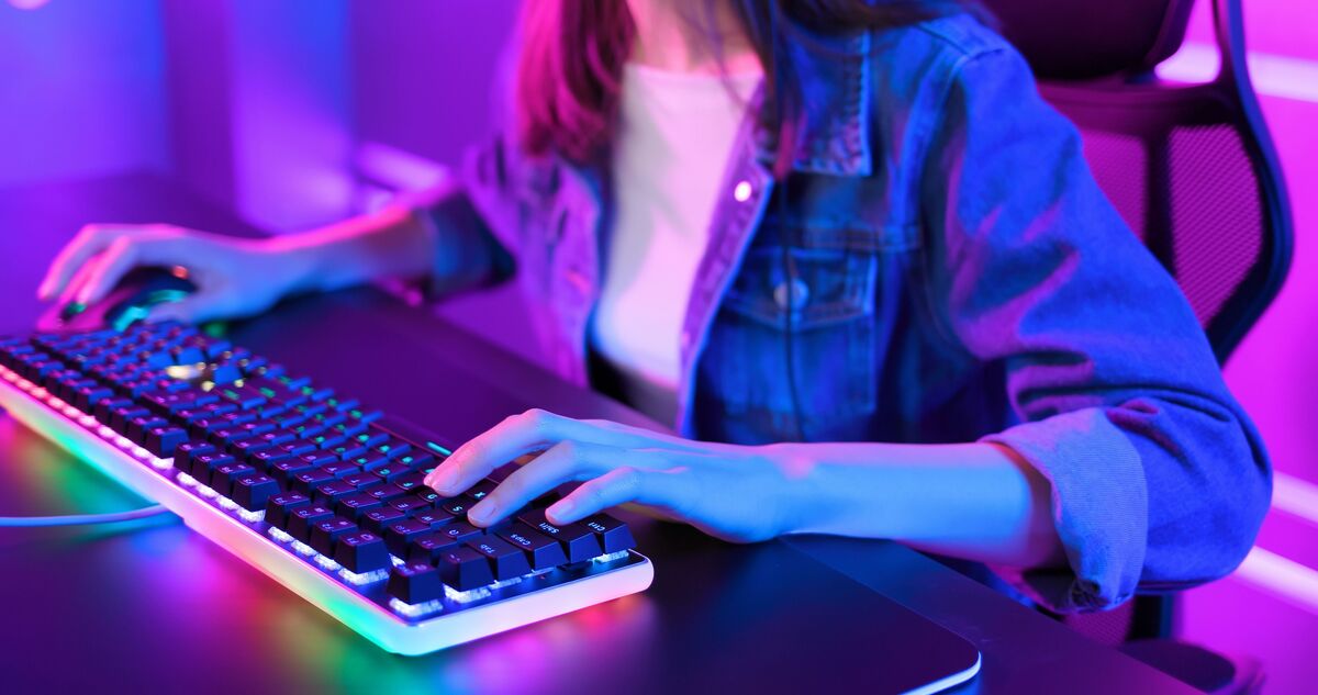 Indivíduo jogando videogame usando o teclado gamer.