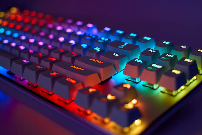 Teclado de computador moderno para jogadores com luz de néon colorida.