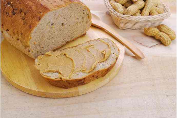 Pão, pasta de amendoim e amendoim na mesa