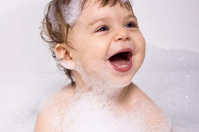Um bebê na banheira sorrindo