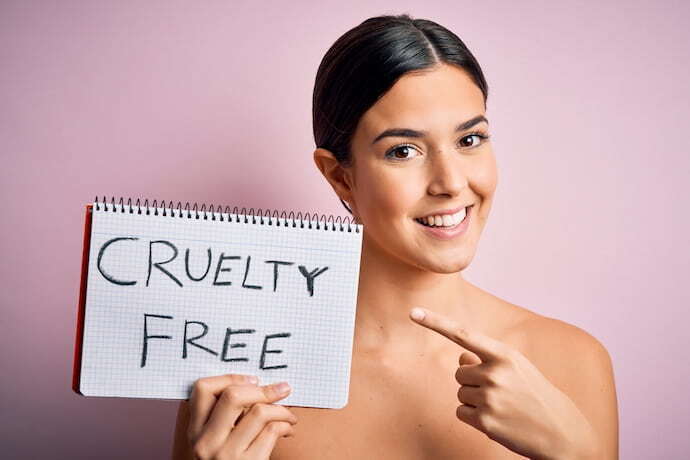 Mulher segurando placa escrito "cruelty free"