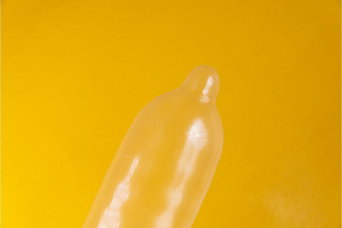 Preservativo de látex em fundo amarelo