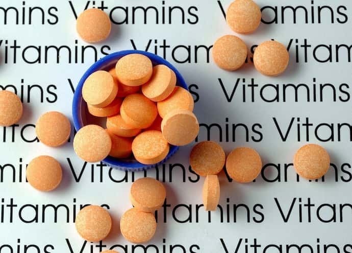 Vitaminas em fundo escrito vitamins