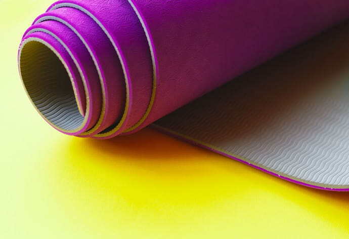 Tapete de yoga roxo em fundo amarelo
