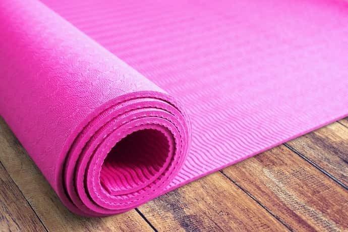 Tapete de yoga rosa em fundo amarelo