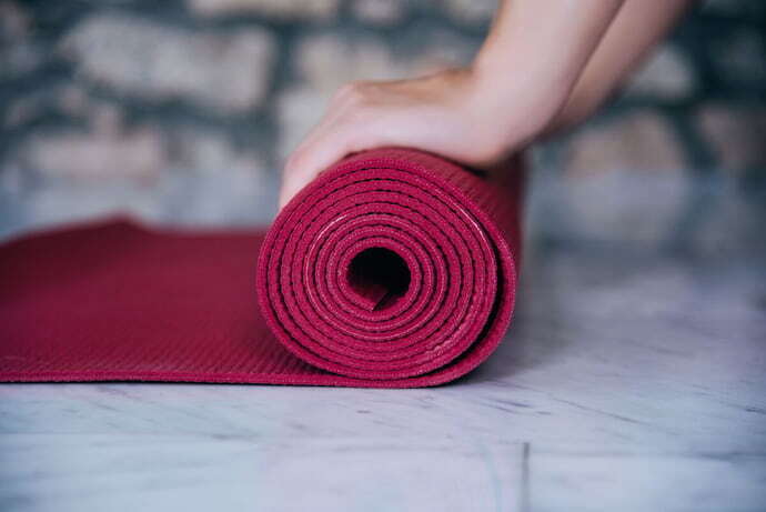 Pessoa enrolando tapete de yoga