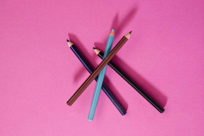 Delineadores lápis de várias cores e fundo rosa