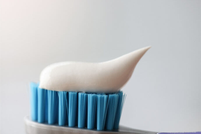 Pasta de dente branca em cima da escova de dente azul
