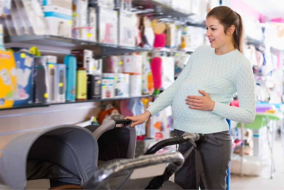 Mulher comprando carrinho para bebê