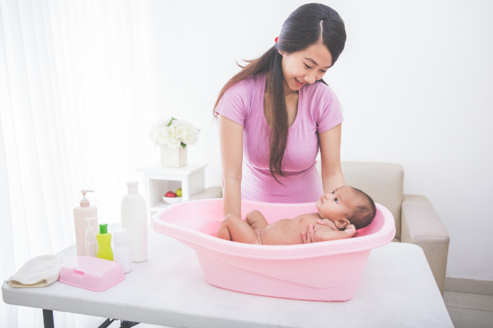 Mãe dando banho no filho recém-nascido