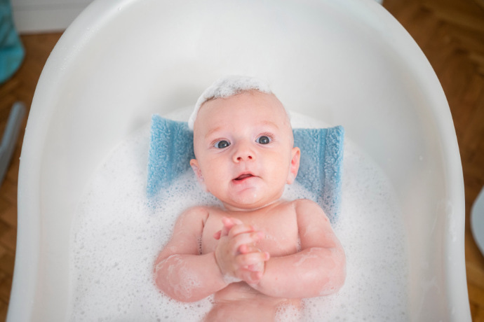 Bebê tomando banho em uma banheira cheia de espuma