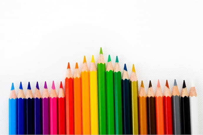 Lápis de cores alinhados em uma fileira e fundo branco