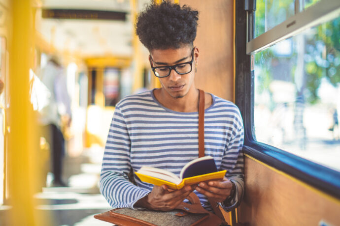 Homem lendo um livro no transporte público