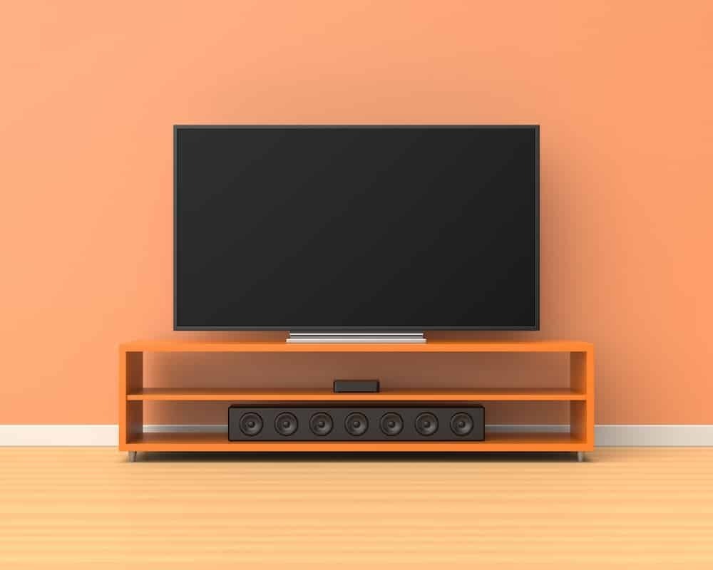 Televisão com soundbar sobre fundo laranja 