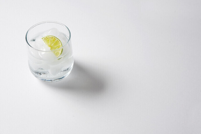 Um copo de gin em fundo cinza