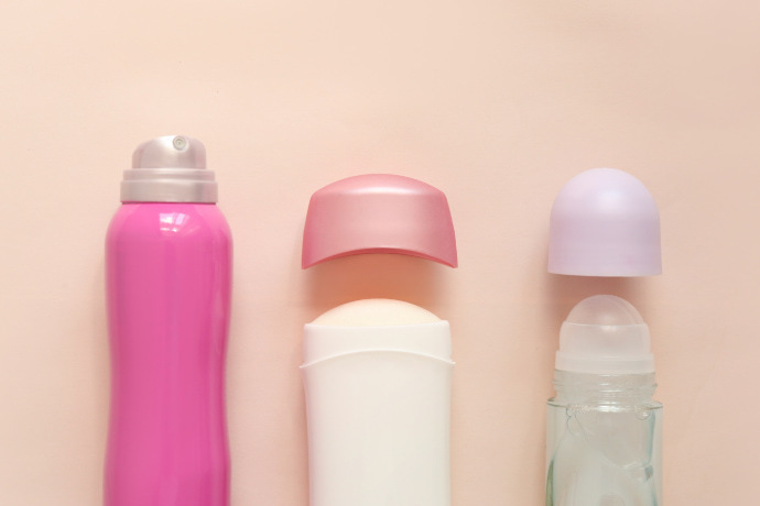 Três diferentes tipos de desodorante em um fundo rosa