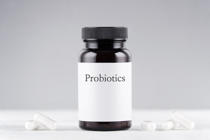 probióticos frasco e cápsulas em cinza