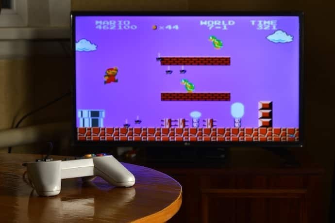 Pessoa jogando jogo do Mario com outro console