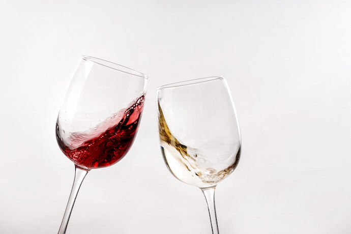 Duas taças de vinhos diferentes fazendo um brinde