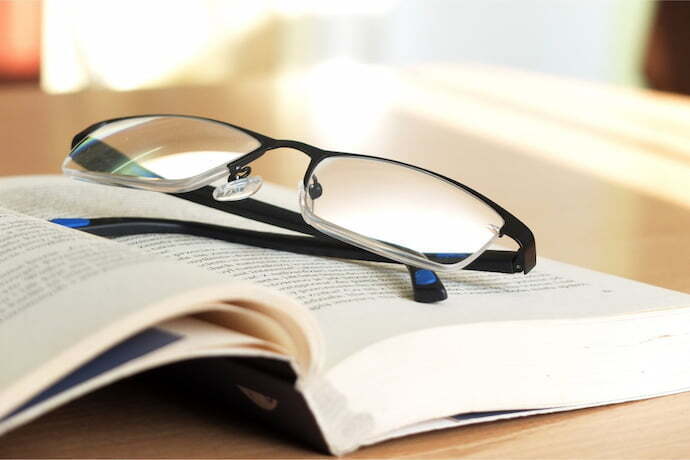óculos em cima de livro aberto