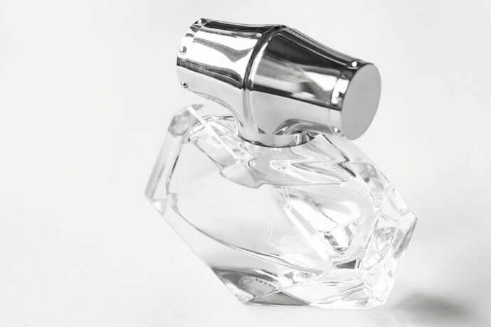 Perfume em um frasco bonito, transparente e fundo branco