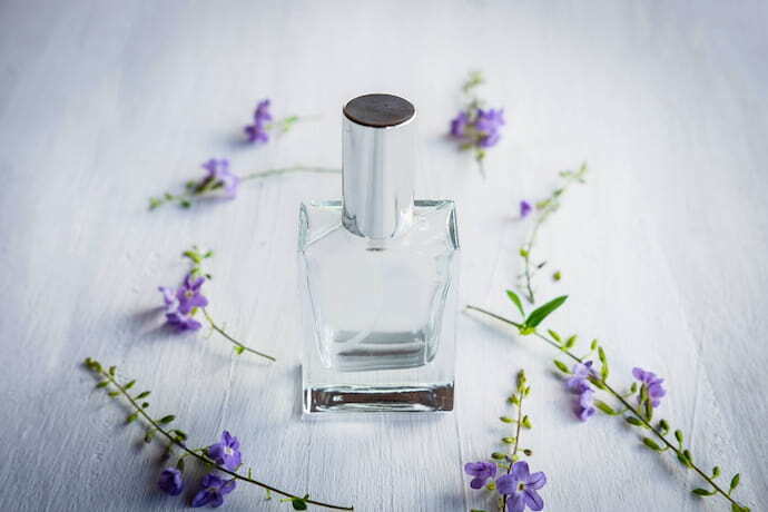 Frasco de perfume e lavanda na mesa de madeira branca