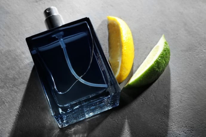 Frasco de perfume masculino moderno e fatias de frutas cítricas