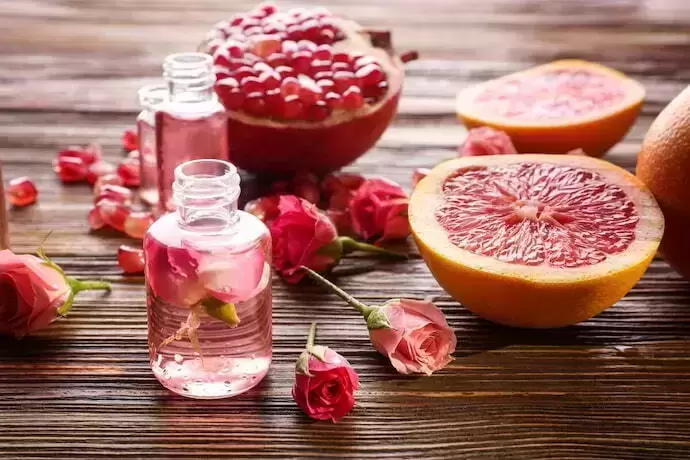 Frasco de perfume com rosas e frutas 
