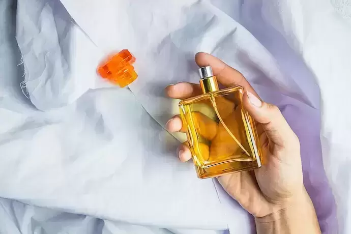 Pessoa segurando frasco de perfume 