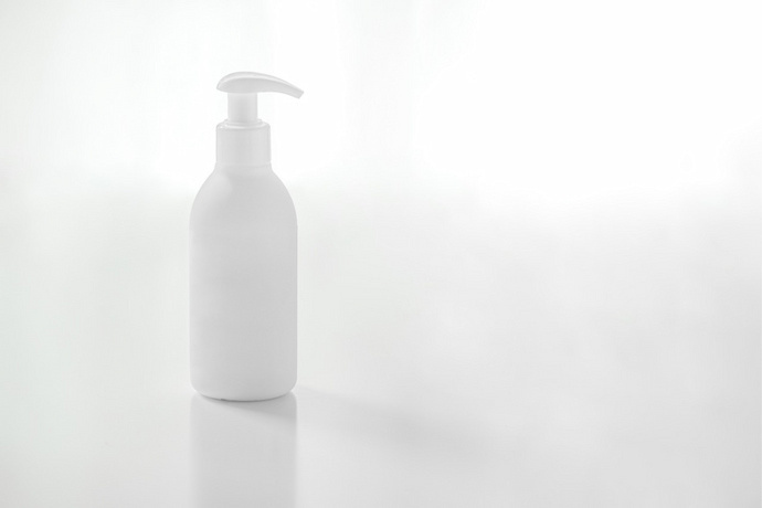 Embalagem branca de shampoo em fundo branco