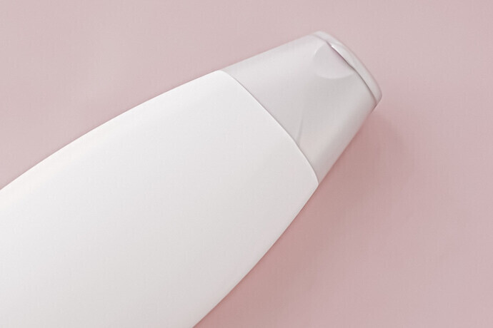 Frasco de shampoo de rótulo em branco no fundo rosa