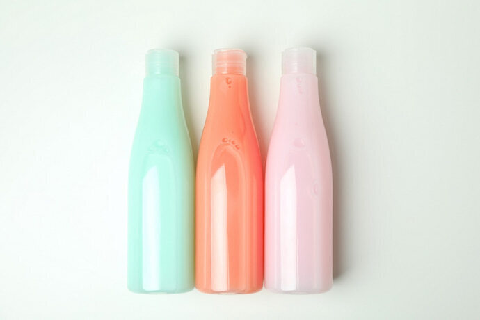 Três frascos de shampoo no fundo branco