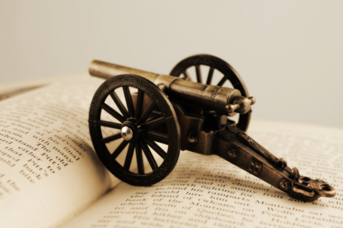 Miniatura de canhão de guerra sobre um livro aberto