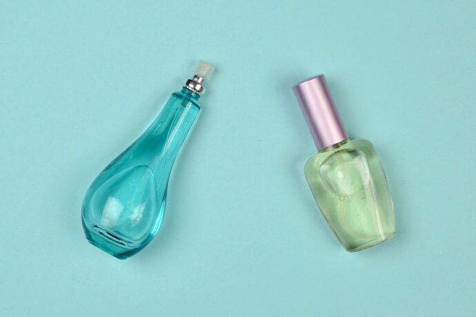 Dois frascos de perfume feminino em um fundo azul pastel