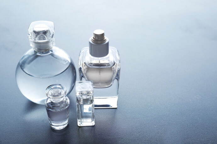 Frascos de perfume diferentes em fundo cinza