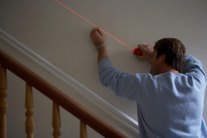 Homem medindo com trena a laser