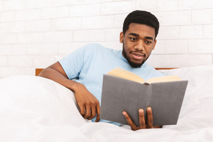 Homem lendo um livro no quarto