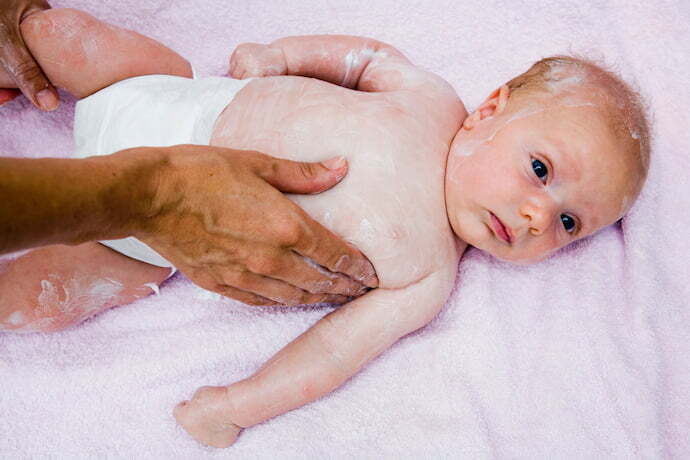 Bebê com hidratante infantil espalhado por todo o corpo