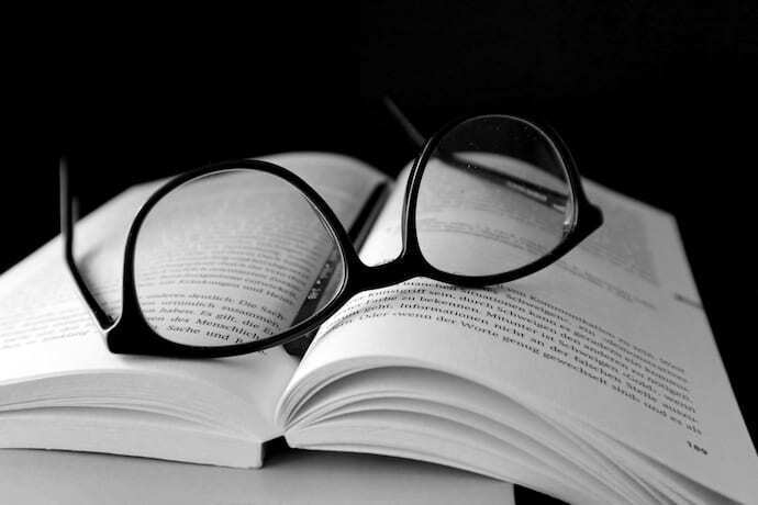 Óculos em cima de livro aberto