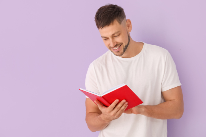 Homem lendo um livro em fundo lilás