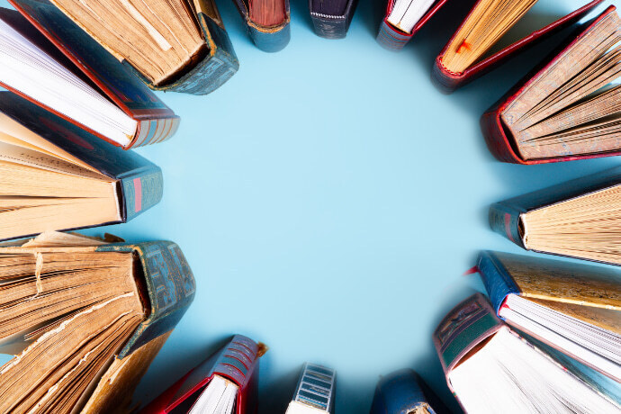 Vários livros organizados formando um círculo em um fundo azul