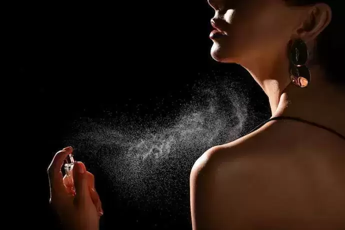 Mulher aplicando perfume