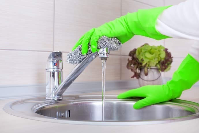 Pessoa limpando torneira