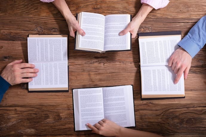 4 Pessoas reunidas lendo livros