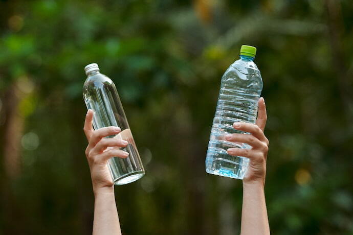 Duas garrafas de água na mão de alguém