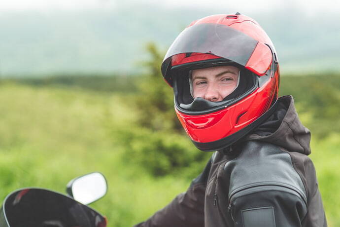 motoqueiro com capa e capacete