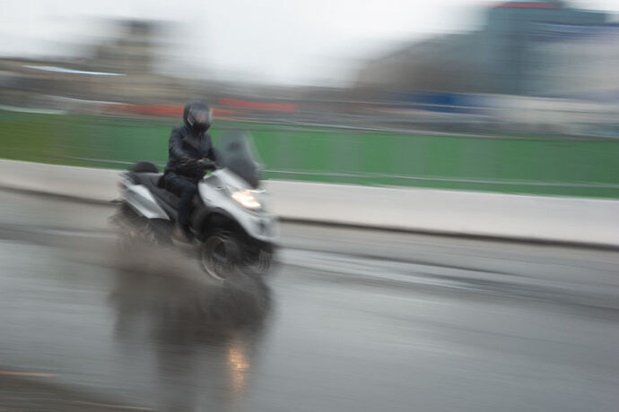 Motoqueiro dirigindo na chuva