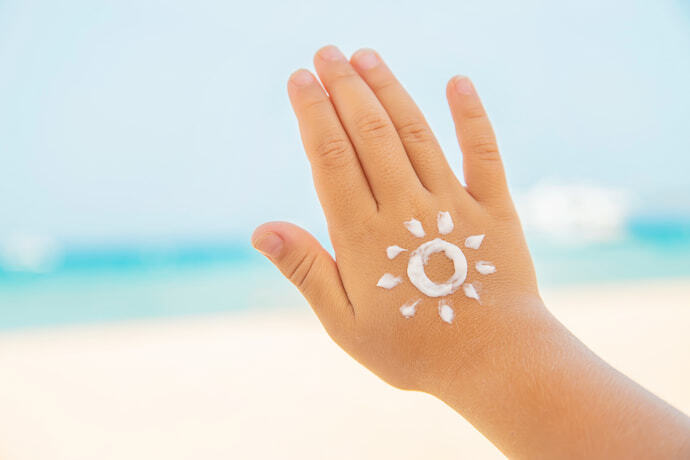Mão de criança com protetor solar